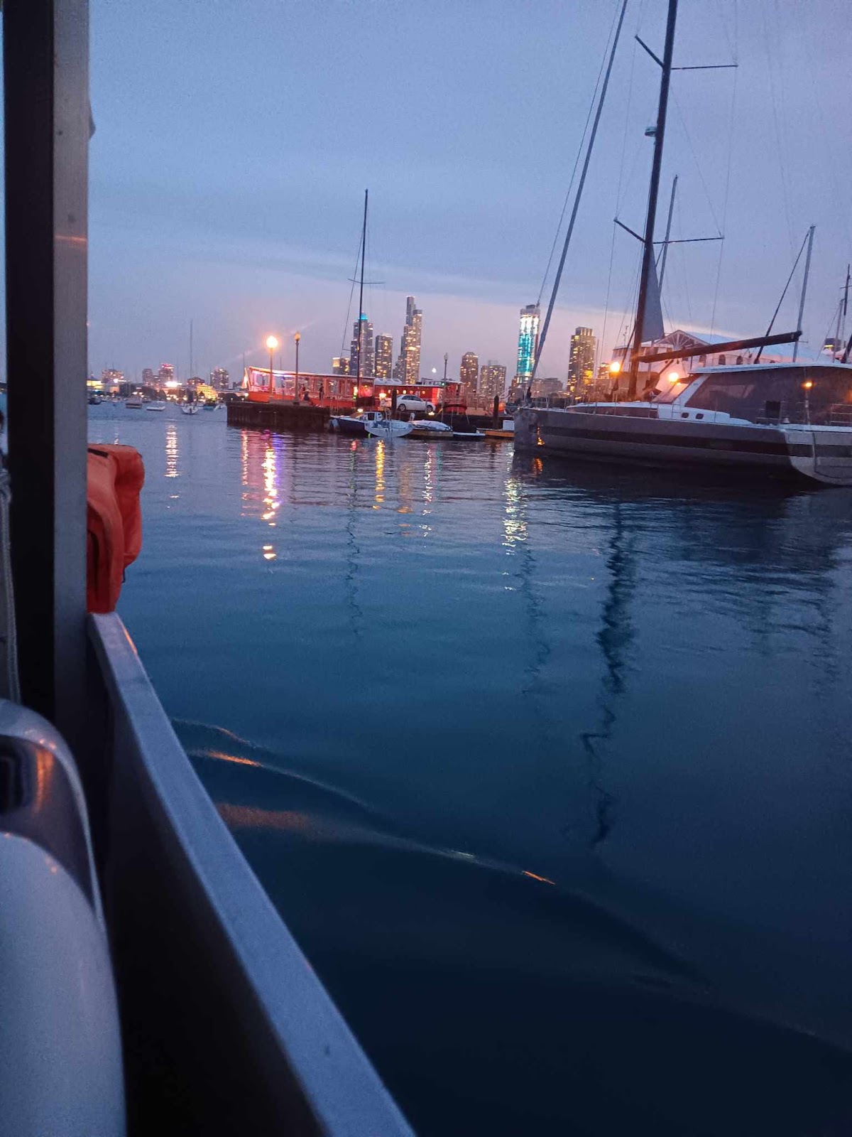 Sailboat masts and harbor lights at twilight